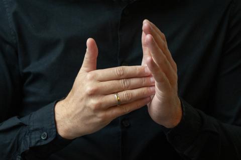 Kadr na dłonie tłumacza języka migowego wykonującego gest